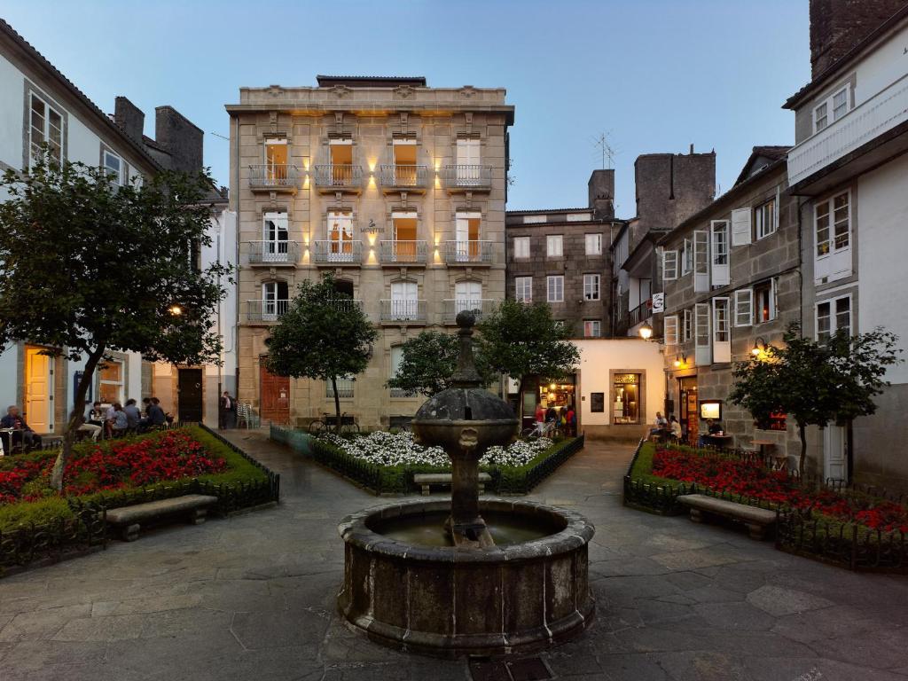 un patio con una fuente frente a un edificio en Hotel Montes, en Santiago de Compostela