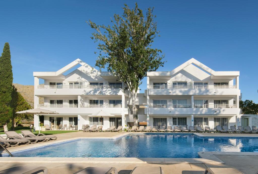 ein großes weißes Gebäude mit einem Pool in der Unterkunft Duvabitat Apartments in Port de Pollença