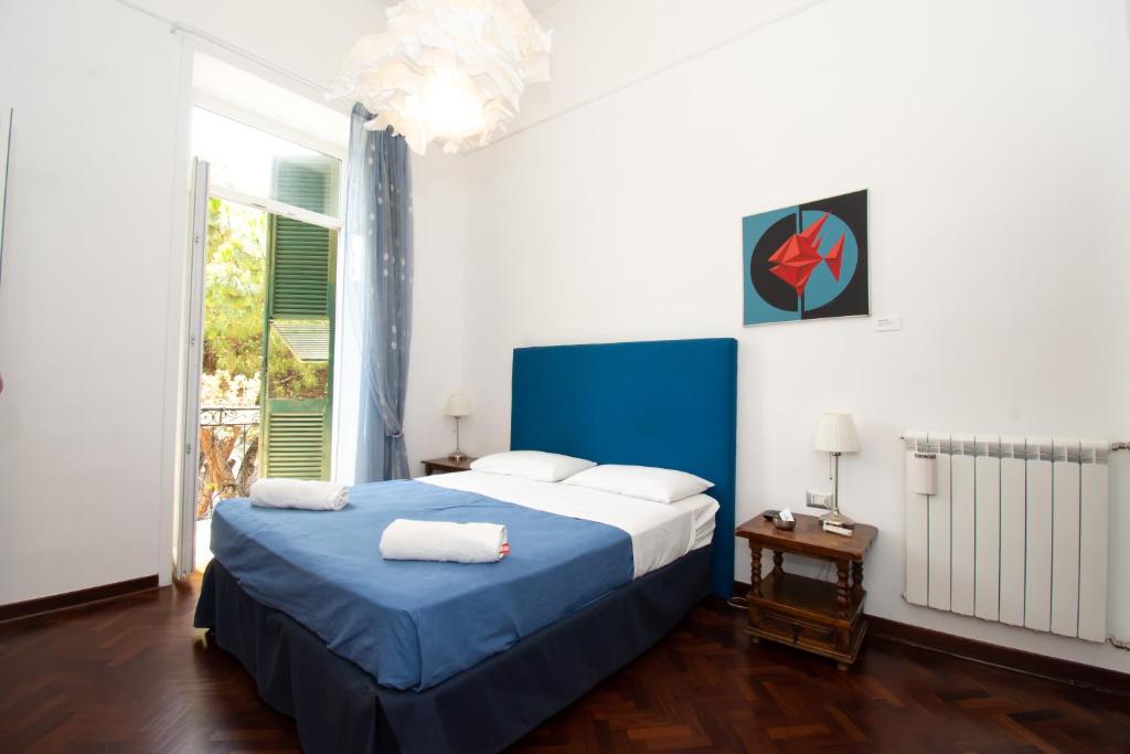 Un dormitorio con una cama azul y una ventana en Areamare, en Nápoles