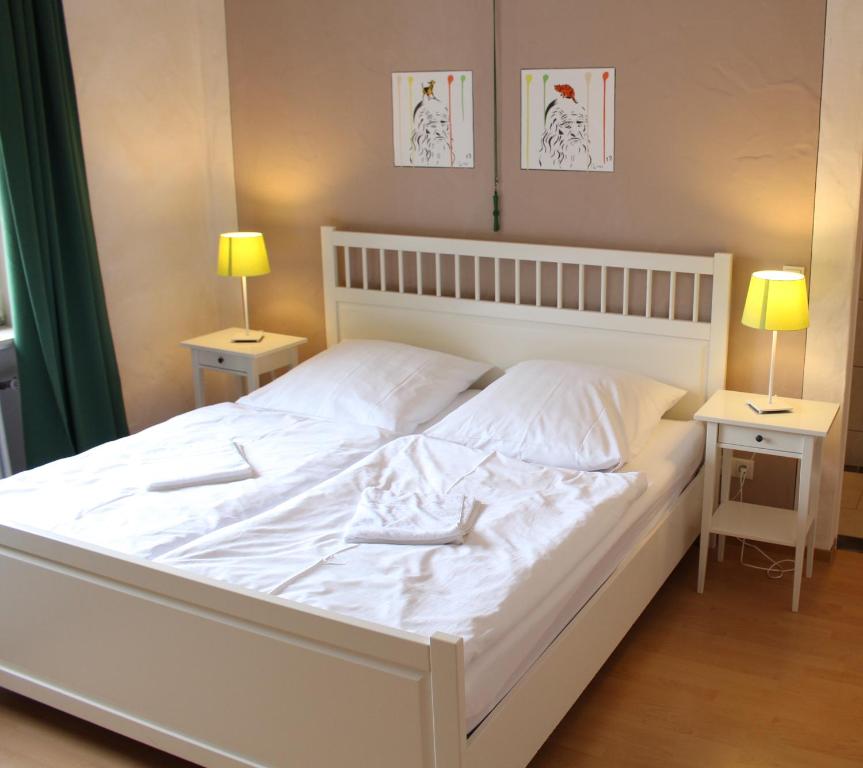 1 cama blanca en un dormitorio con 2 mesitas de noche en Pastis - Staffless with Self Check-In, en Pillig
