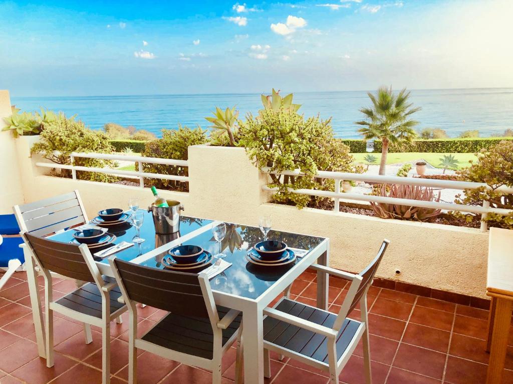 een tafel en stoelen op een patio met uitzicht op de oceaan bij lovely sea views apartment on La Costa del Sol in Mijas Costa