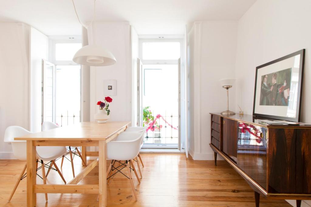 リスボンにあるBairrus Lisbon Apartments - Graçaのダイニングルーム(木製テーブル、白い椅子付)