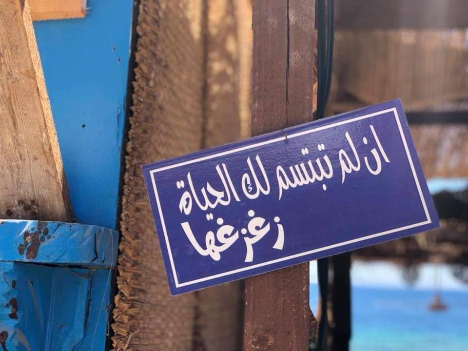 un cartello è attaccato a una recinzione di legno di Arzu Tents a Dahab