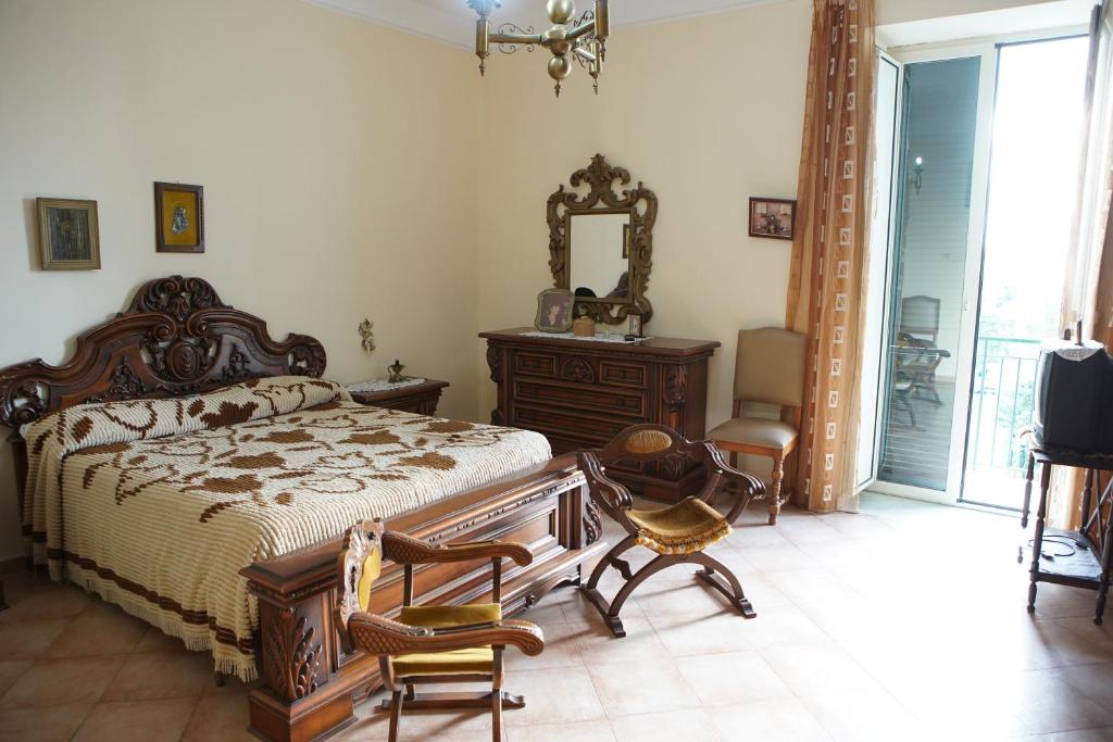 sypialnia z łóżkiem, lustrem i krzesłami w obiekcie CASA VACANZE da Rosy w mieście Ercolano