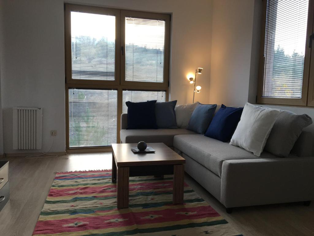 ein Wohnzimmer mit einem Sofa und einem Couchtisch in der Unterkunft Newly refurbished spacious and cosy apartment St. John in Bansko