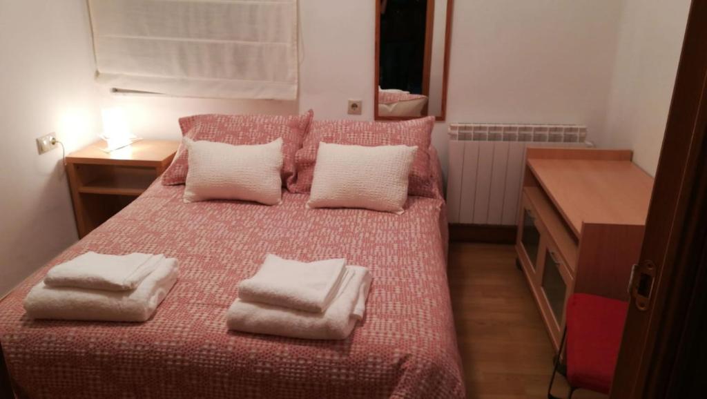 ein Schlafzimmer mit einem Bett mit weißen Handtüchern darauf in der Unterkunft Céntrico y luminoso San Vicente in Salamanca