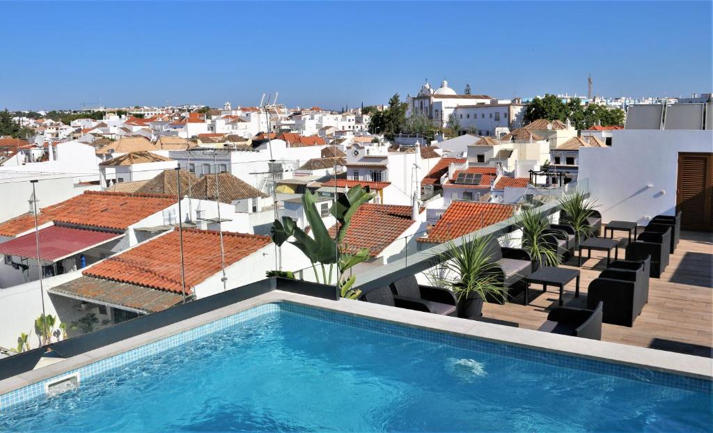 a swimming pool on the roof of a building at Authentic Tavira Hotel in Tavira