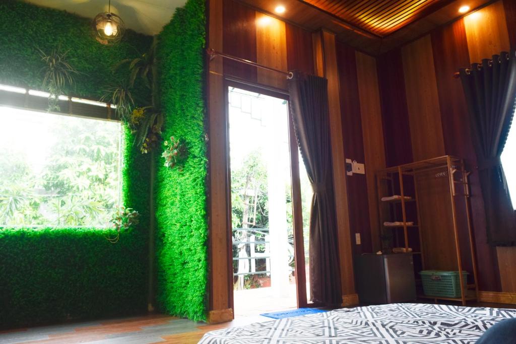 a room with a green wall with a sliding glass door at Hà Tiên Homestay in Ha Tien