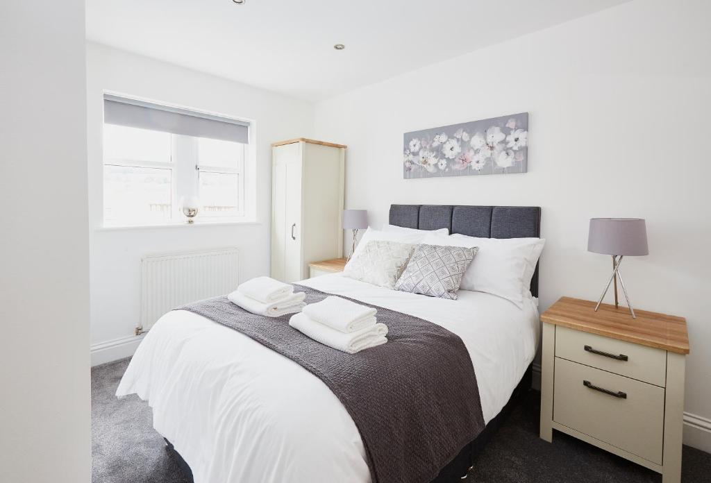 a bedroom with a bed with two towels on it at Listers Lodge in Halifax