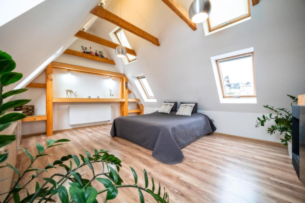 1 dormitorio con 1 cama en un loft con tragaluces en Willa w Ubocy - "Jacuzzi i Sauna w ofercie dodatkowo płatnej", en Murzasichle