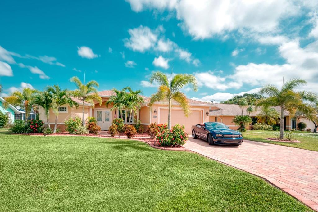 ein Haus mit einem Auto, das in einer Einfahrt geparkt ist in der Unterkunft Villa Holiday Sunrise in Cape Coral