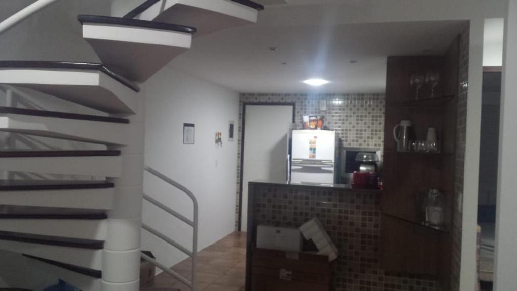 a staircase in a room with a kitchen and a kitchen at FLAT 212 Condomínio Villa Hípica Gravatá in Gravatá