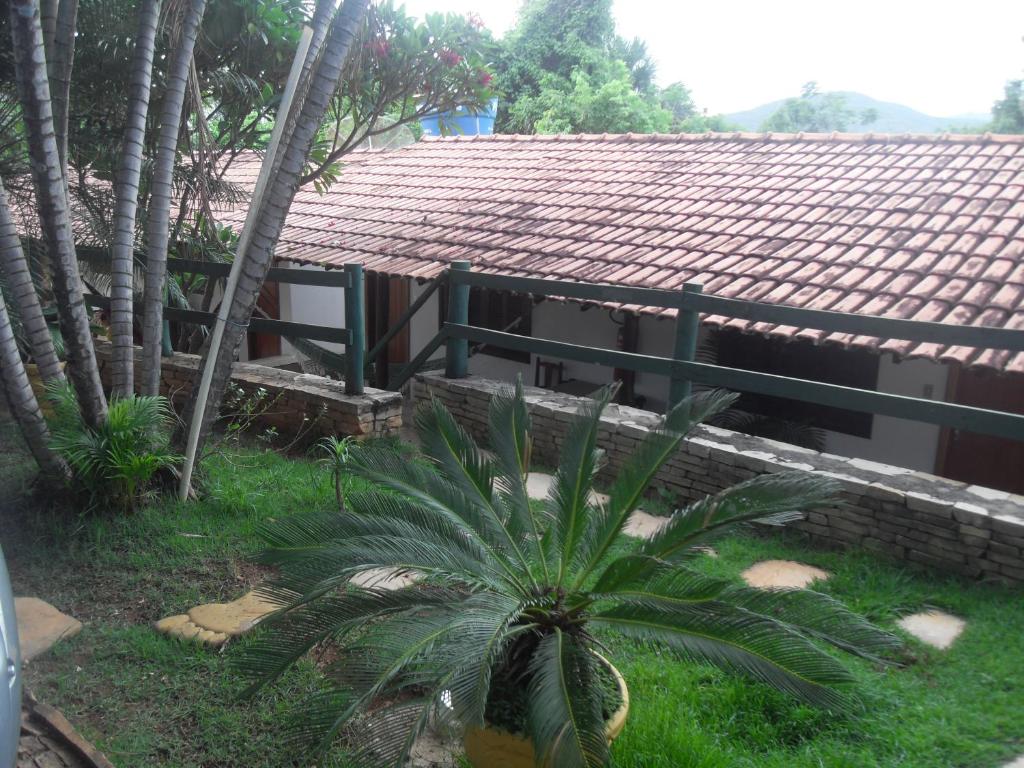 una casa con techo de baldosa y palmera en Pousada Estrela Matutina, en Pirenópolis