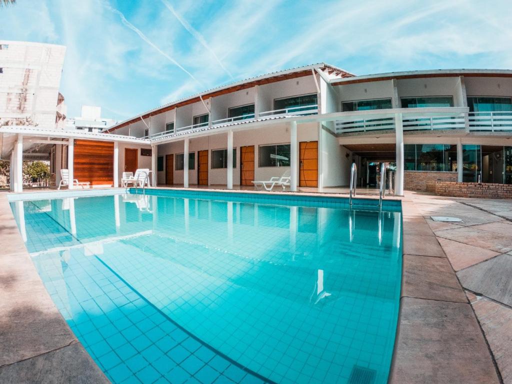 a swimming pool in front of a building at Pousada Marina Porto in Itacuruçá