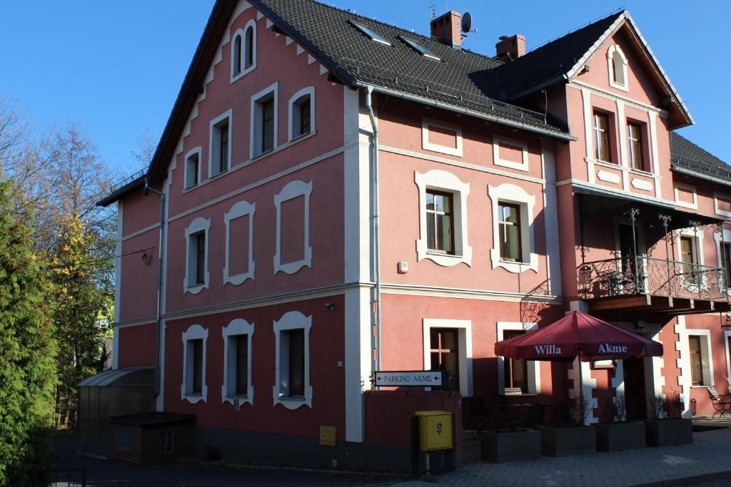 ein großes rotweißes Gebäude mit einem Regenschirm in der Unterkunft Willa Akme in Stronie Śląskie