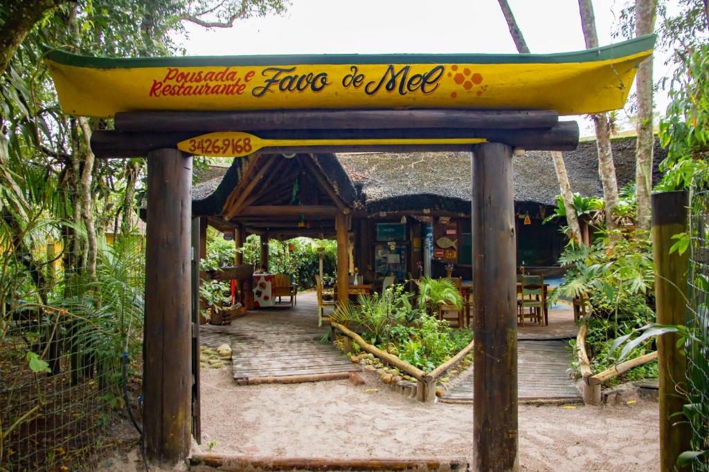 a sign for a restaurant in a garden at Pousada Favo De Mel in Ilha do Mel