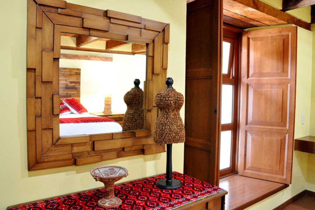 a mirror in a bedroom with a bed and a dresser at Casa Santa Lucia in San Cristóbal de Las Casas