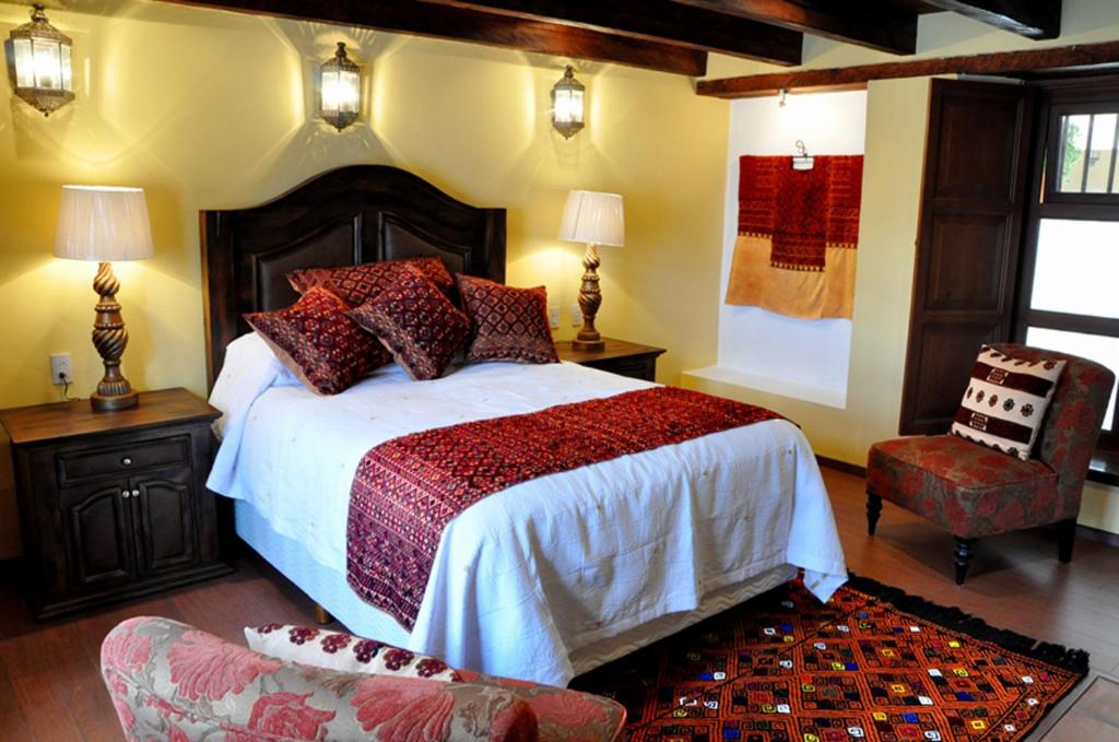 1 dormitorio con 1 cama grande y 1 silla en Casa Santa Lucia en San Cristóbal de Las Casas