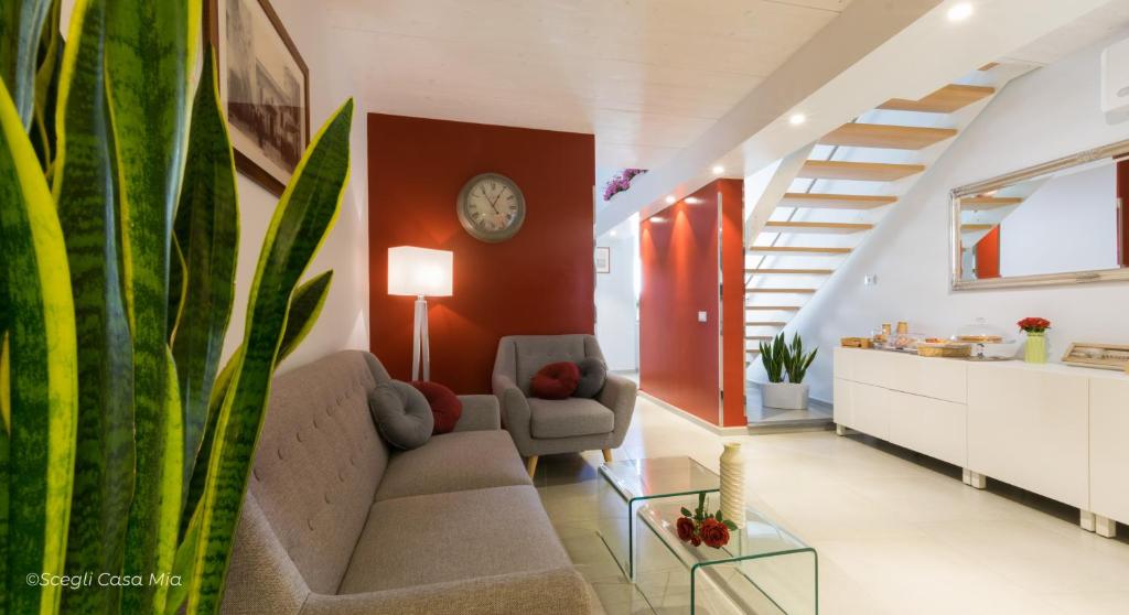 a living room with a couch and a clock on the wall at Ottocento Guest House in Alghero