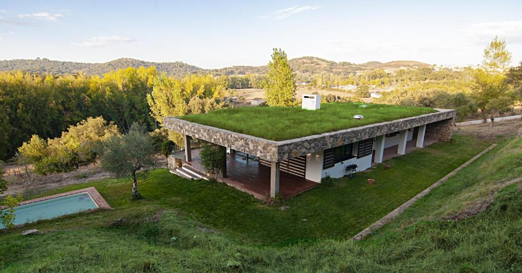 een uitzicht op een huis met een grasdak bij Vivienda Rural Olivar del Chanza in Cortegana