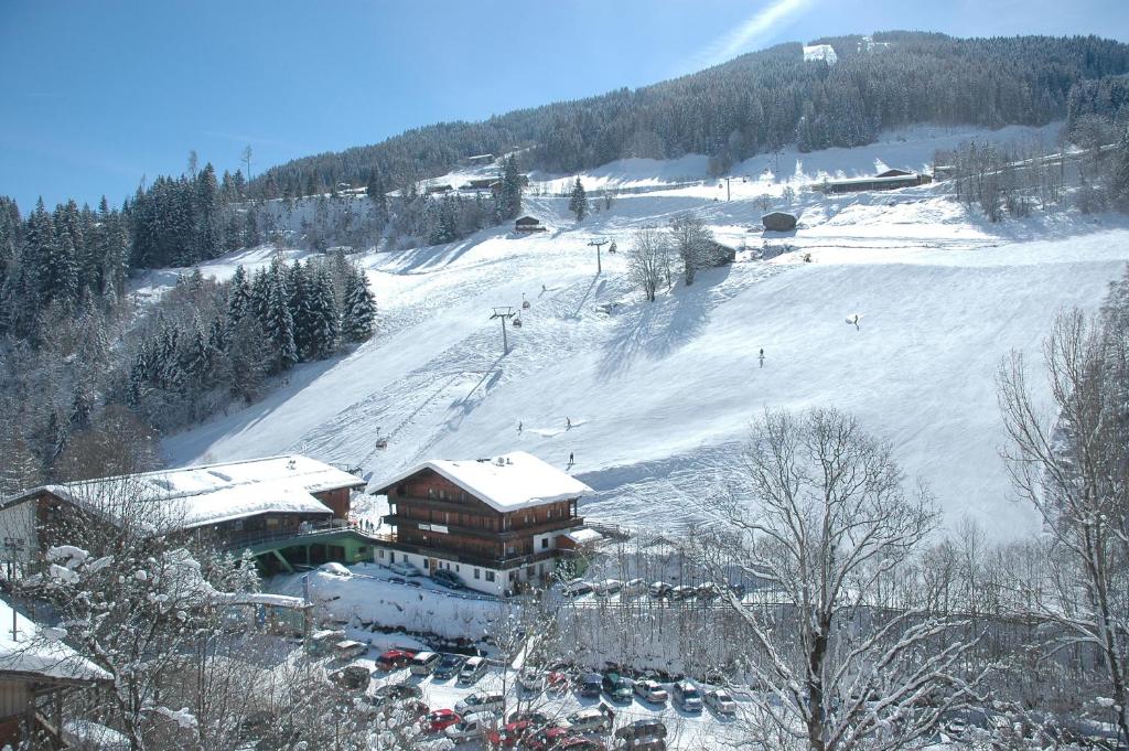 eine Skilodge auf einer schneebedeckten Piste mit Skifahrern in der Unterkunft Liftstüberl in Alpbach