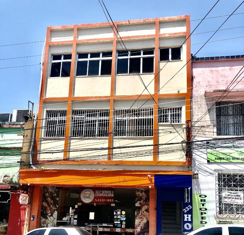 un grand bâtiment avec des fenêtres donnant sur une rue de la ville dans l'établissement Hotel Fortaleza III Manaus, à Manaus