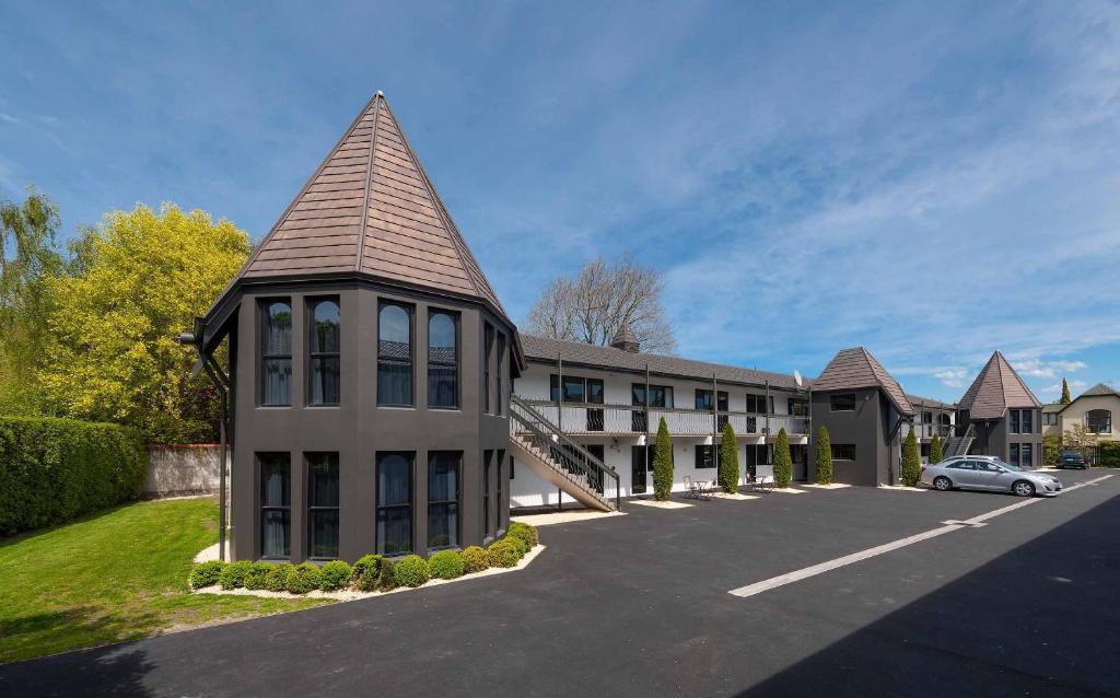 a building with a pointed roof in a parking lot at The Towers on the Park in Christchurch