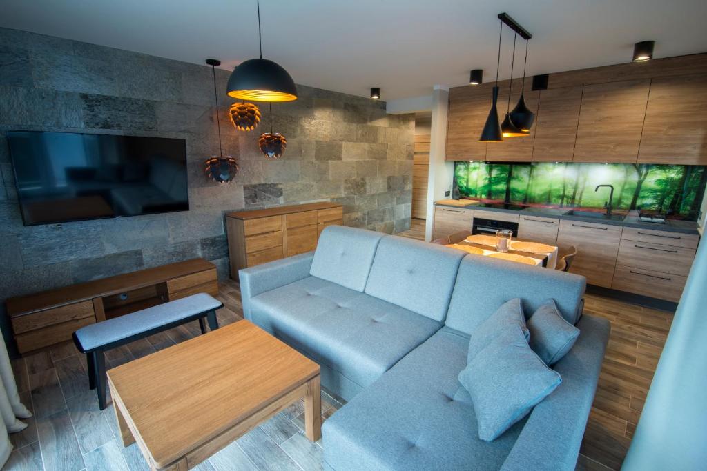 a living room with a blue couch and a table at Szklarska Perełka in Szklarska Poręba