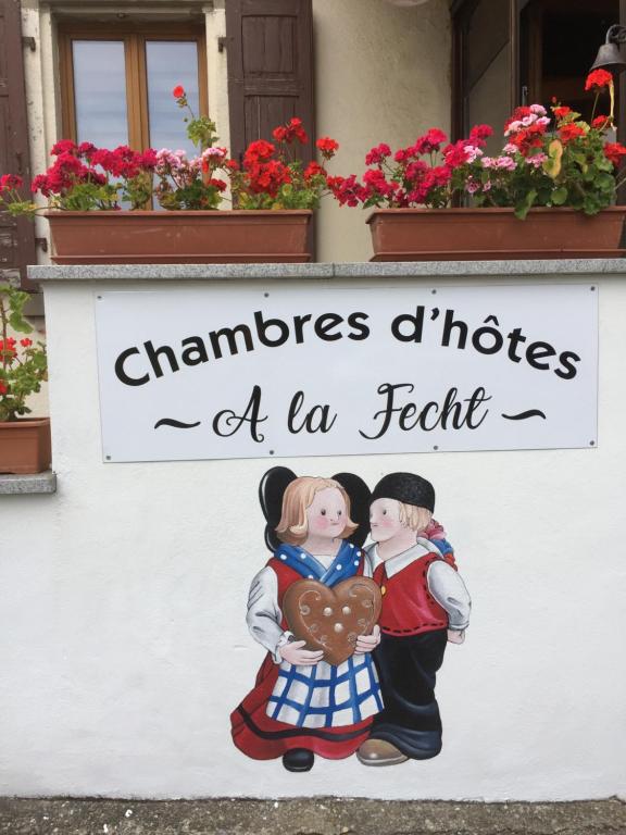 a sign of two people holding a heart at Chambres d'hôtes A la Fecht Nature et Bien-être in Sondernach