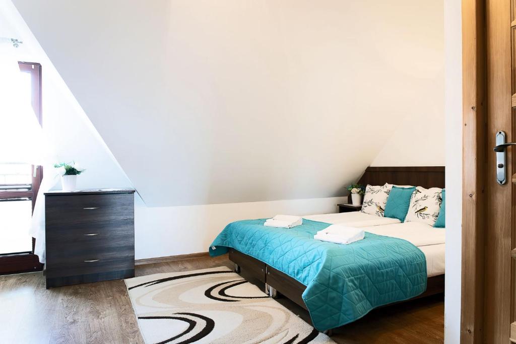 Postel nebo postele na pokoji v ubytování Rodzinny Dom i Apartamenty u Ciwersa z balią w ogrodzie