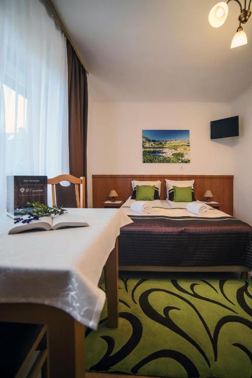 Postel nebo postele na pokoji v ubytování Rodzinny Dom i Apartamenty u Ciwersa z balią w ogrodzie