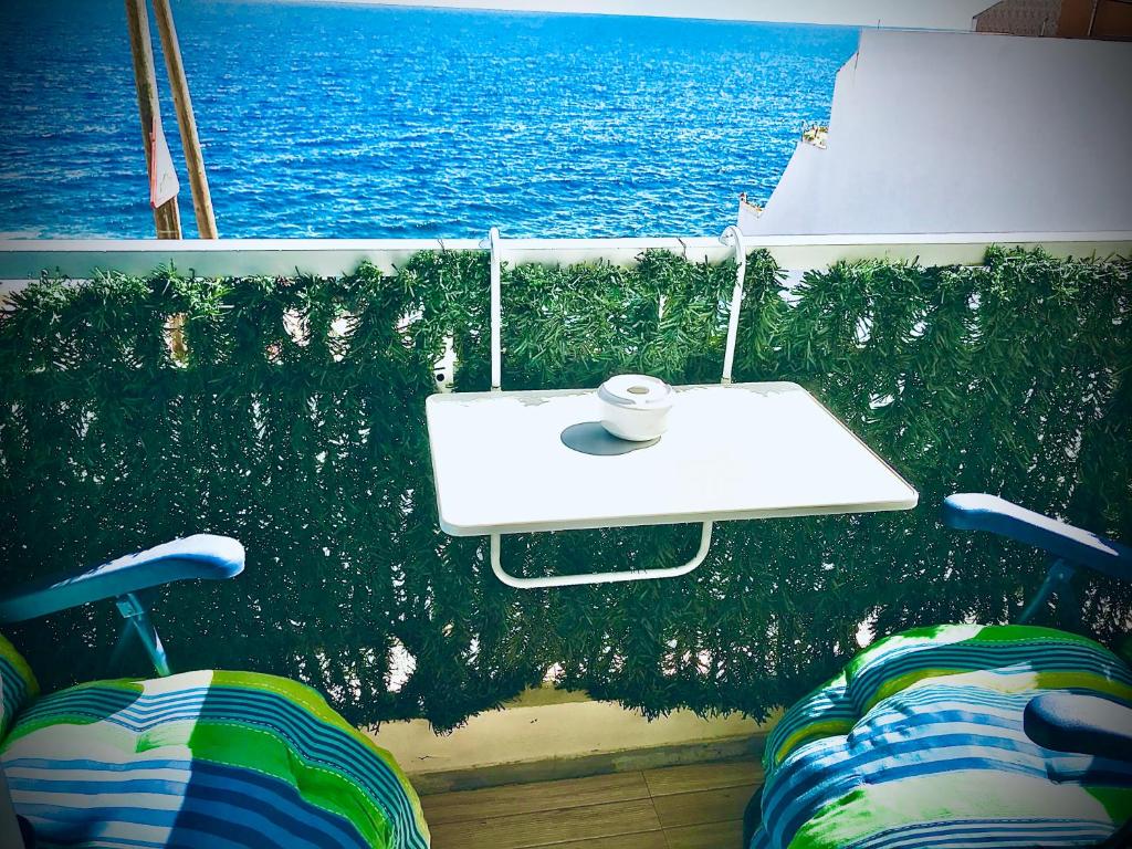 a white table and chairs on a balcony overlooking the ocean at Bruno´s House Apartment in Pájara