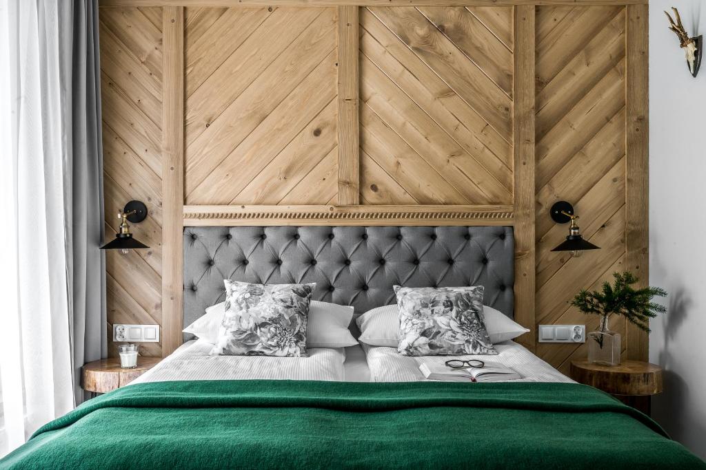 a bedroom with a green bed with a wooden headboard at Willa pod Orłem - Zakopane in Zakopane