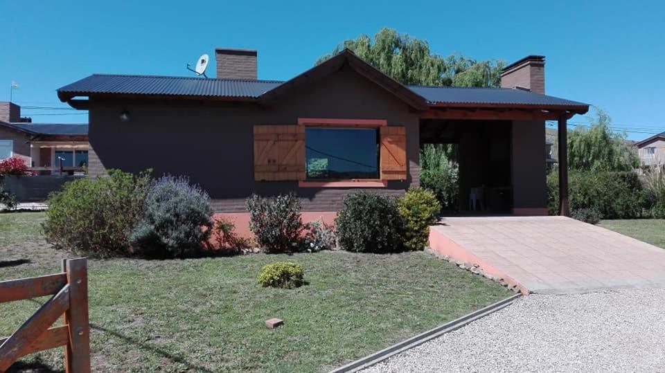 una casa marrón con una ventana en un patio en Cabañas Lemunko en Sierra de la Ventana