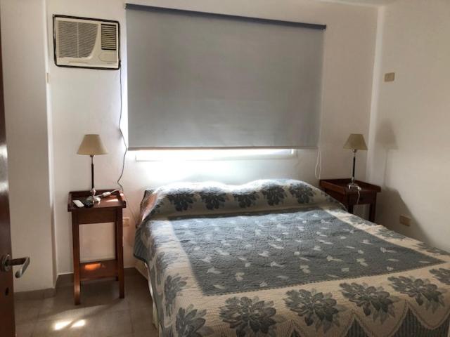 a bedroom with a bed and a window with a fan at Saint Michel Unidad Superior in Alta Gracia