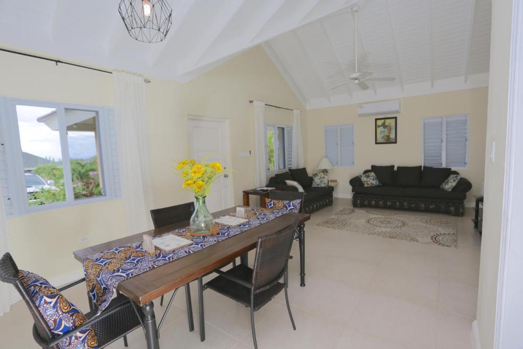 a living room with a table with chairs and a couch at Richmond - Heroes Villa, North Coast, Gated, Access to Swimming Pool, Playground & Private Beach - Welcome Basket in Richmond