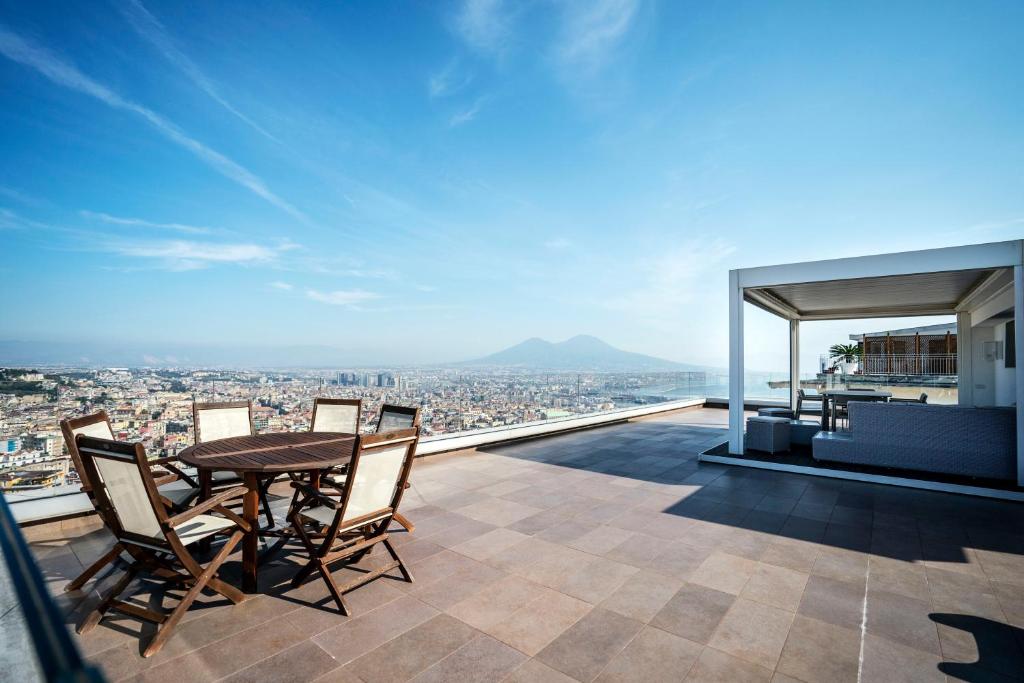 une table et des chaises sur le toit d'un bâtiment dans l'établissement Terrazza Manù - loft suspended over the city-Vomero, à Naples
