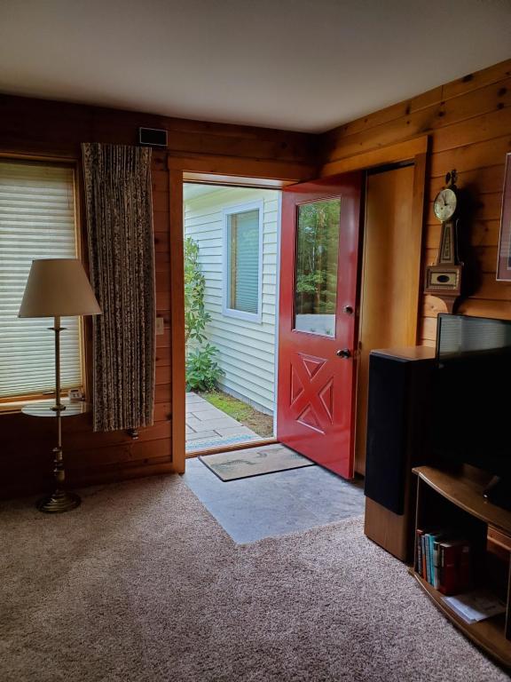 eine rote Tür in einem Wohnzimmer mit einer Tür in der Unterkunft Kenway Ranch in Southwest Harbor