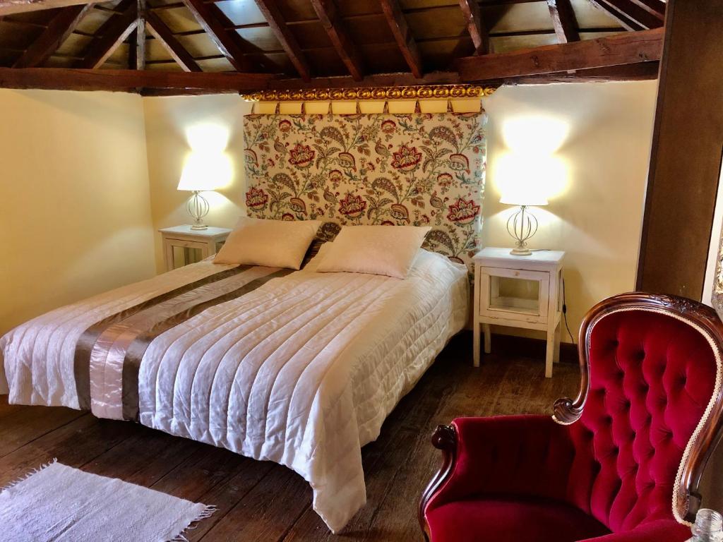 a bedroom with a bed and a red chair at Hotel Rural Vilaflor Self Check In 24h in Vilaflor