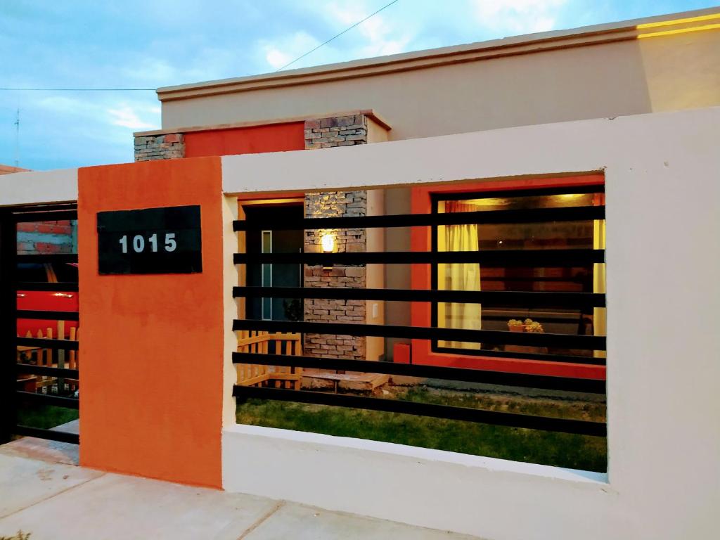 Un bâtiment orange et blanc avec une horloge. dans l'établissement Casa En Gregores, à Gobernador Gregores