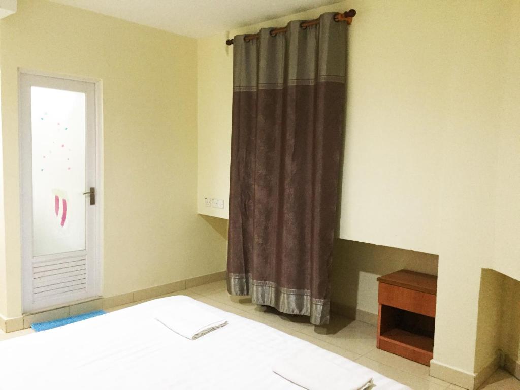 a bedroom with a bed and a window at HK Inn Hua Kiew Inn in Miri