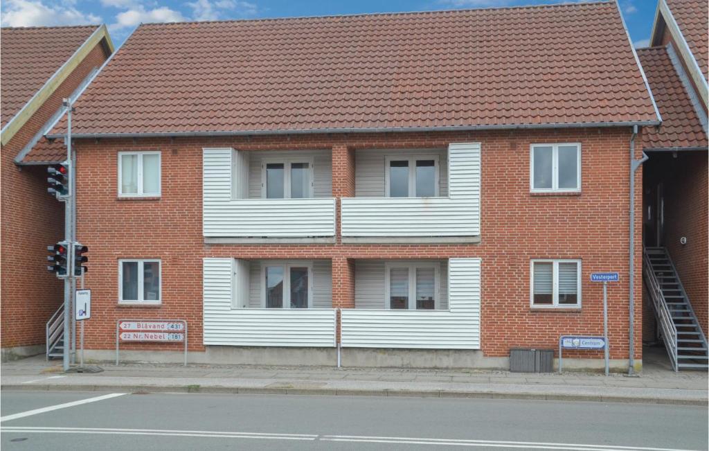 un edificio de ladrillo rojo con una casa blanca en Cozy Apartment In Varde With Kitchen, en Varde