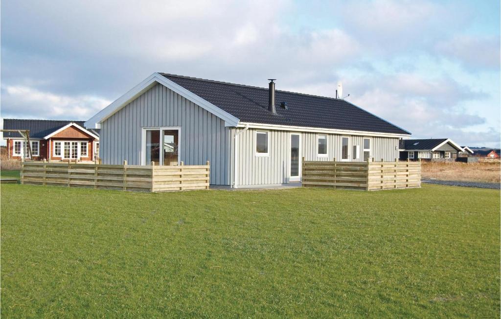 una casa blanca con techo negro en un campo de hierba en Cozy Home In Harbore With Kitchen, en Harboør