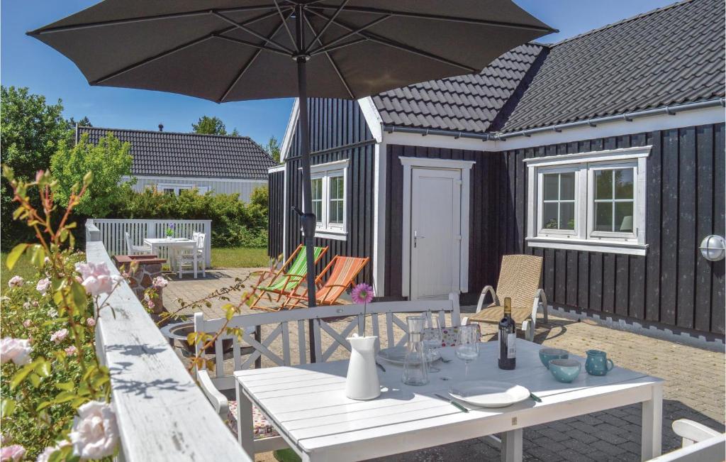 a picnic table with an umbrella in front of a tiny house at Awesome Home In Vejby With 3 Bedrooms, Sauna And Wifi in Vejby