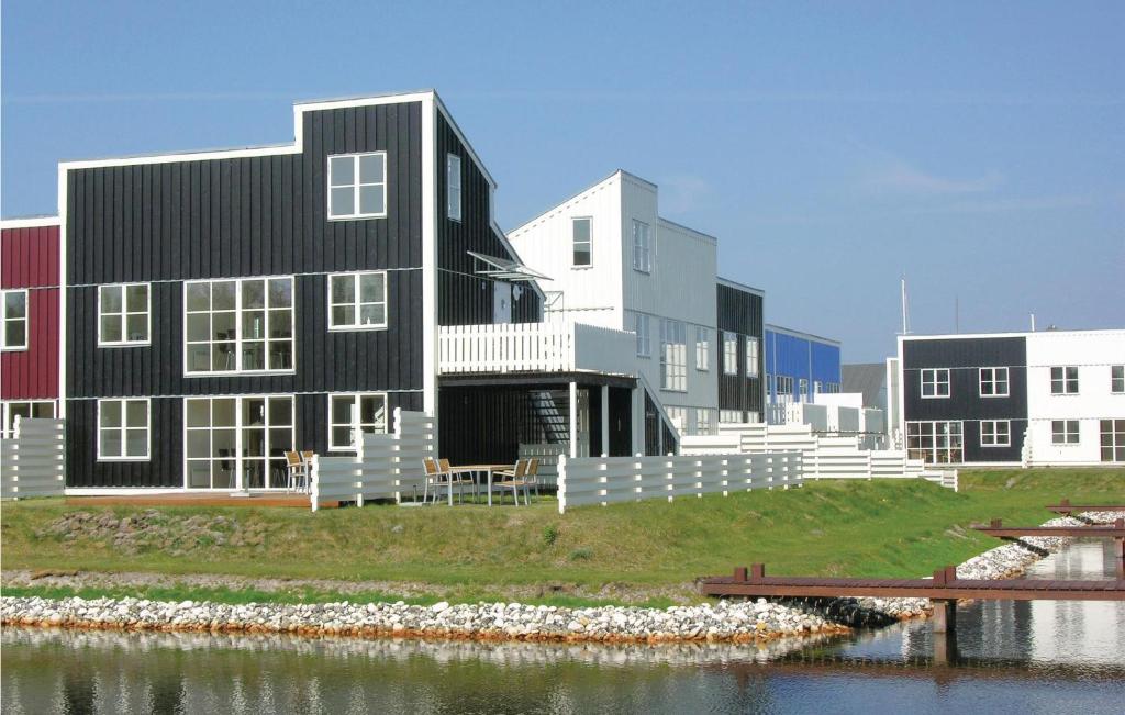 un bâtiment noir et blanc à côté d'une masse d'eau dans l'établissement Rejen 223, à Ebeltoft