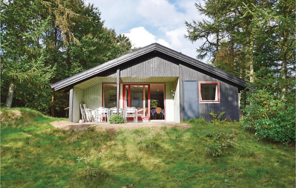 een klein grijs huis met een veranda in een veld bij 4 Bedroom Awesome Home In Tim in Tim