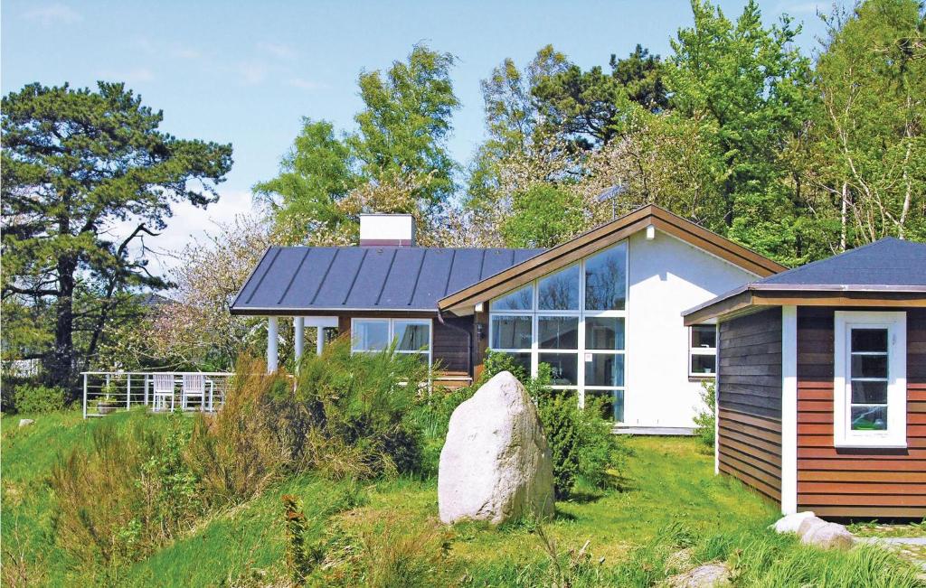 a small house with a solar roof on a field at Nice Home In Rnne With 4 Bedrooms, Sauna And Wifi in Rønne