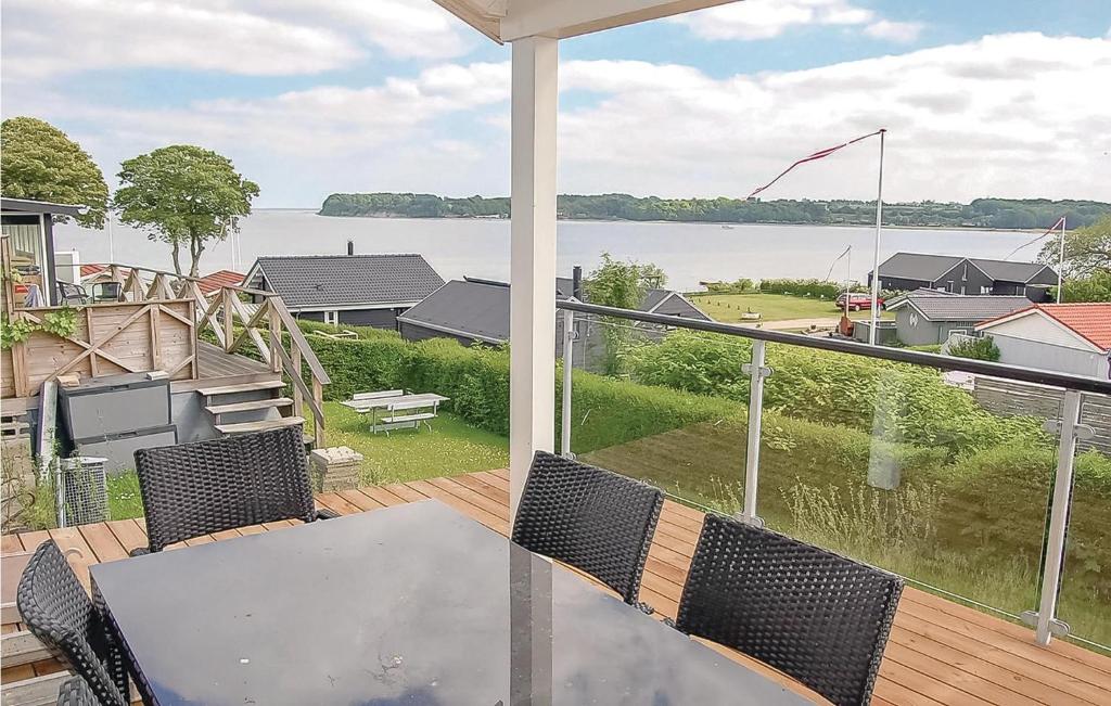 balcón con mesa, sillas y vistas al agua en Awesome Home In Hejls With Kitchen, en Hejls