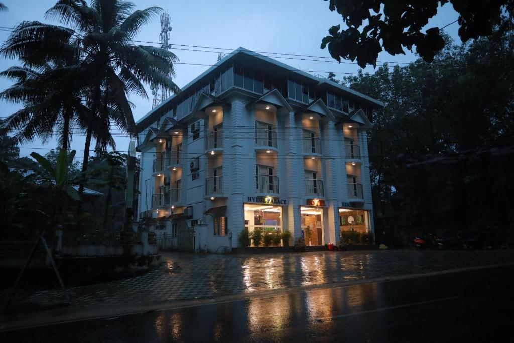 um grande edifício numa rua chuvosa à noite em Hydel Palace Hotel & Resorts By Bestinn Leisure Athirappally em Athirappilly