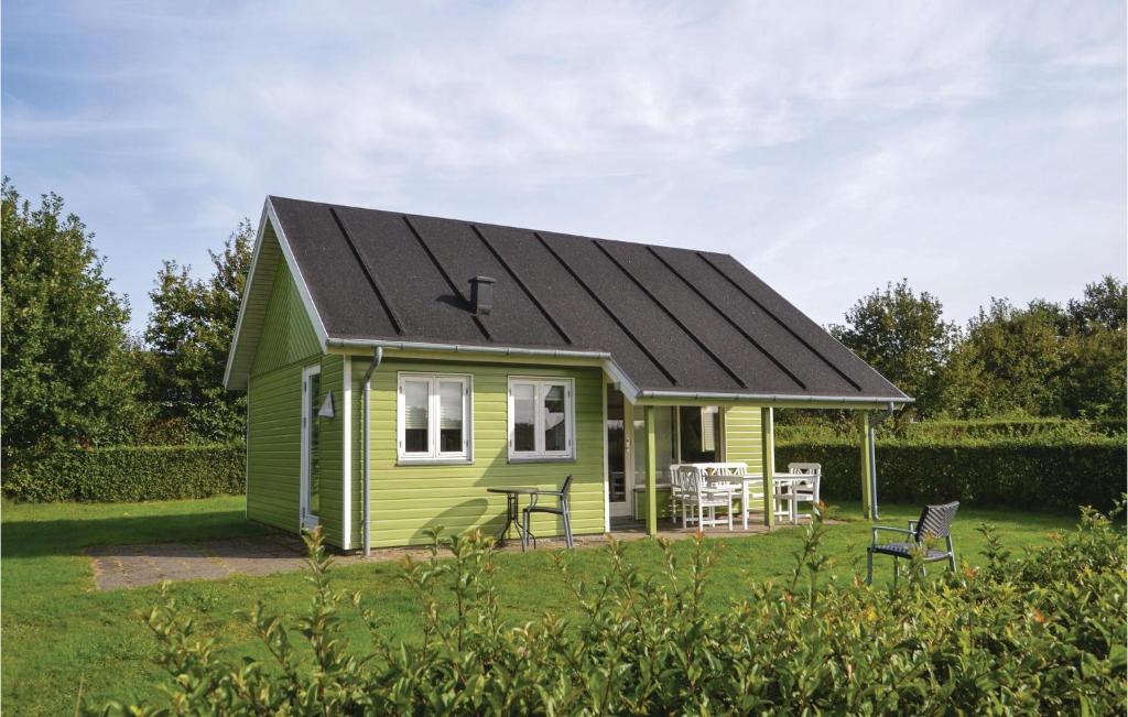Stunning Home In Grindsted With Kitchen في Tofterup: منزل صغير أخضر على سقف أسود